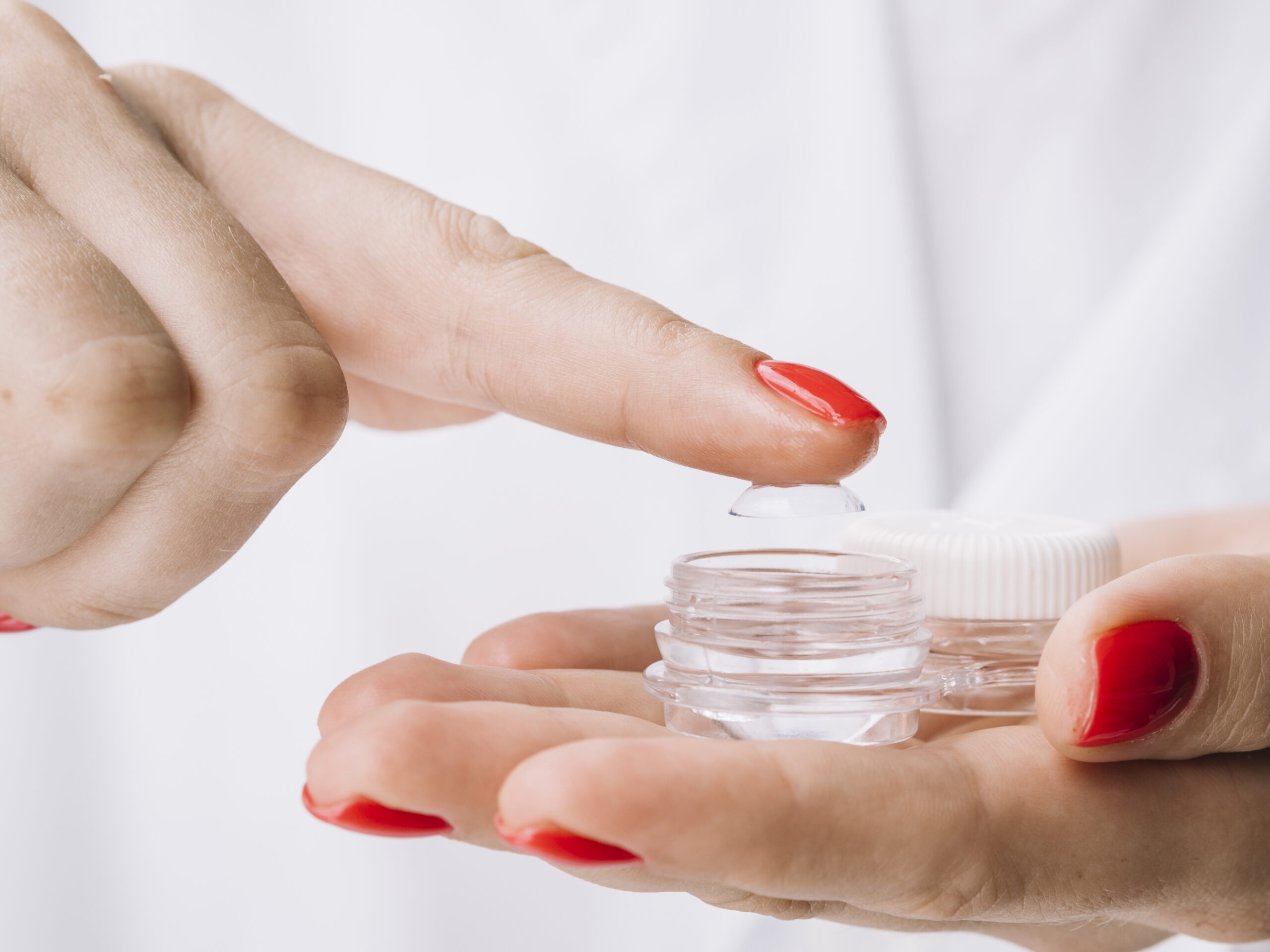 vrouw haalt lens uit lenzenpotje